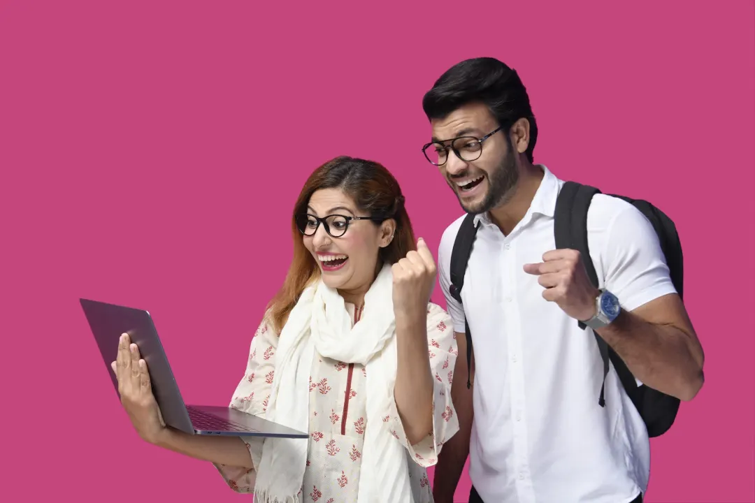 Two young professionals celebrating in front of a laptop